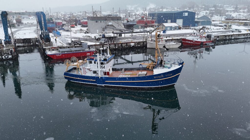Fishing vessel Manon-Yvon in a snowy port in the Magdalen Islands, captured in the middle of winter maneuvers.
